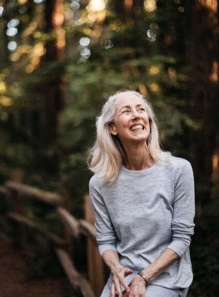 Annie Carpenter, SmartFLOW Yoga photo of Annie Carpenter smiling with trees blurred in background
